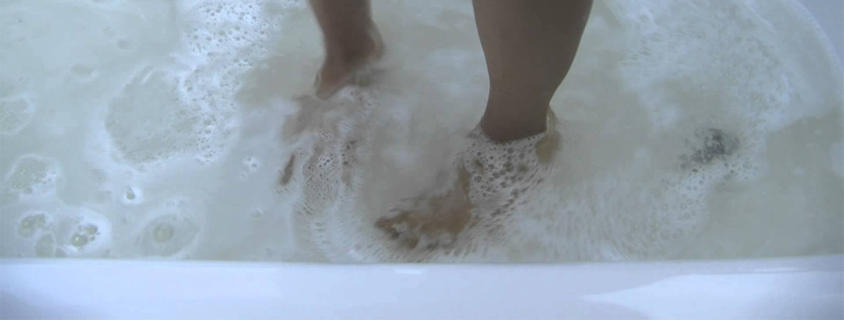 A person 's feet in the tub with foam.