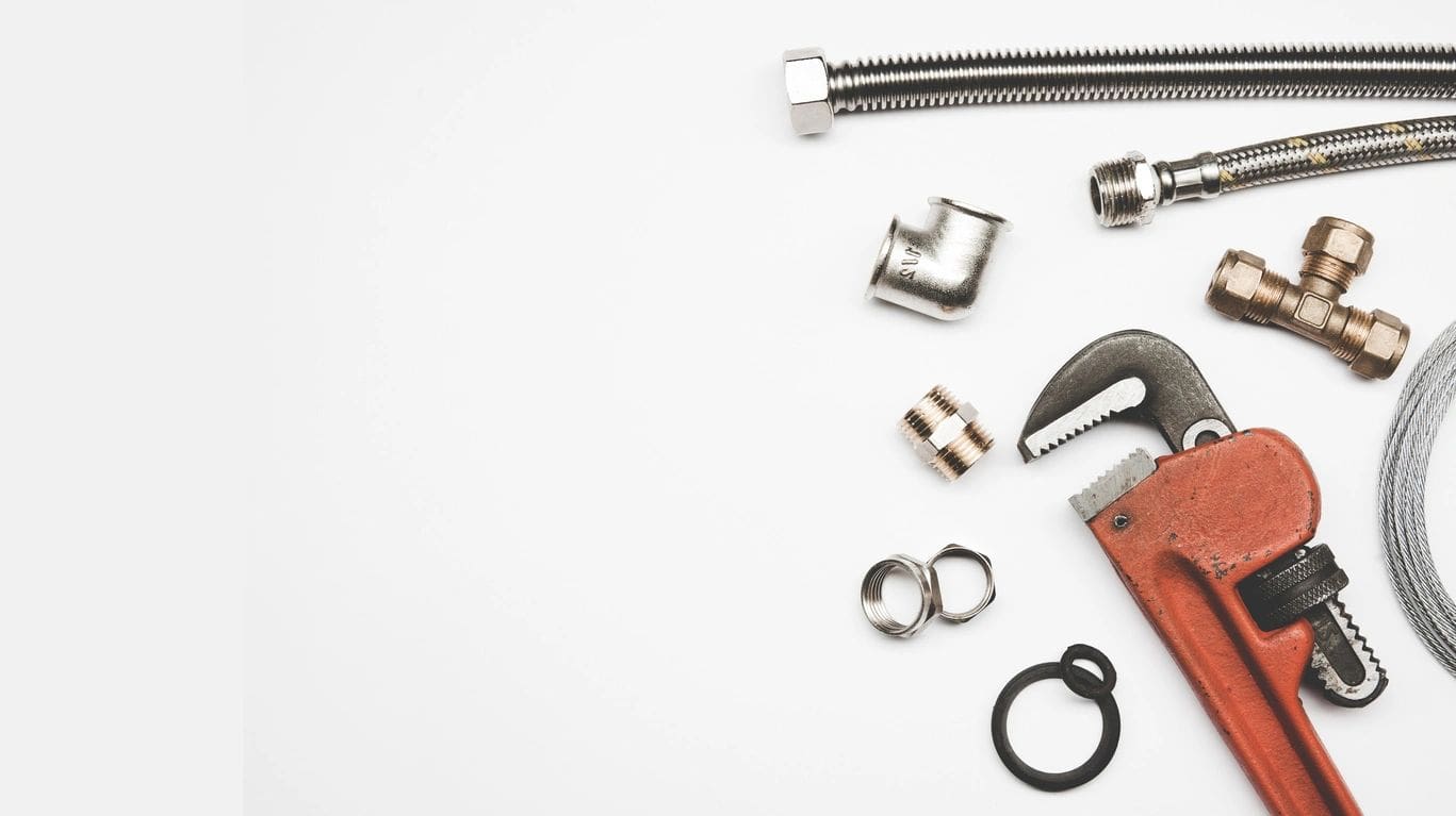 A white table topped with lots of metal items.