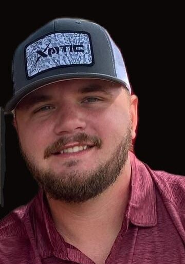 A man with a beard and hat smiling for the camera.