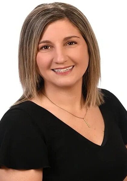 A woman in black shirt smiling for the camera.