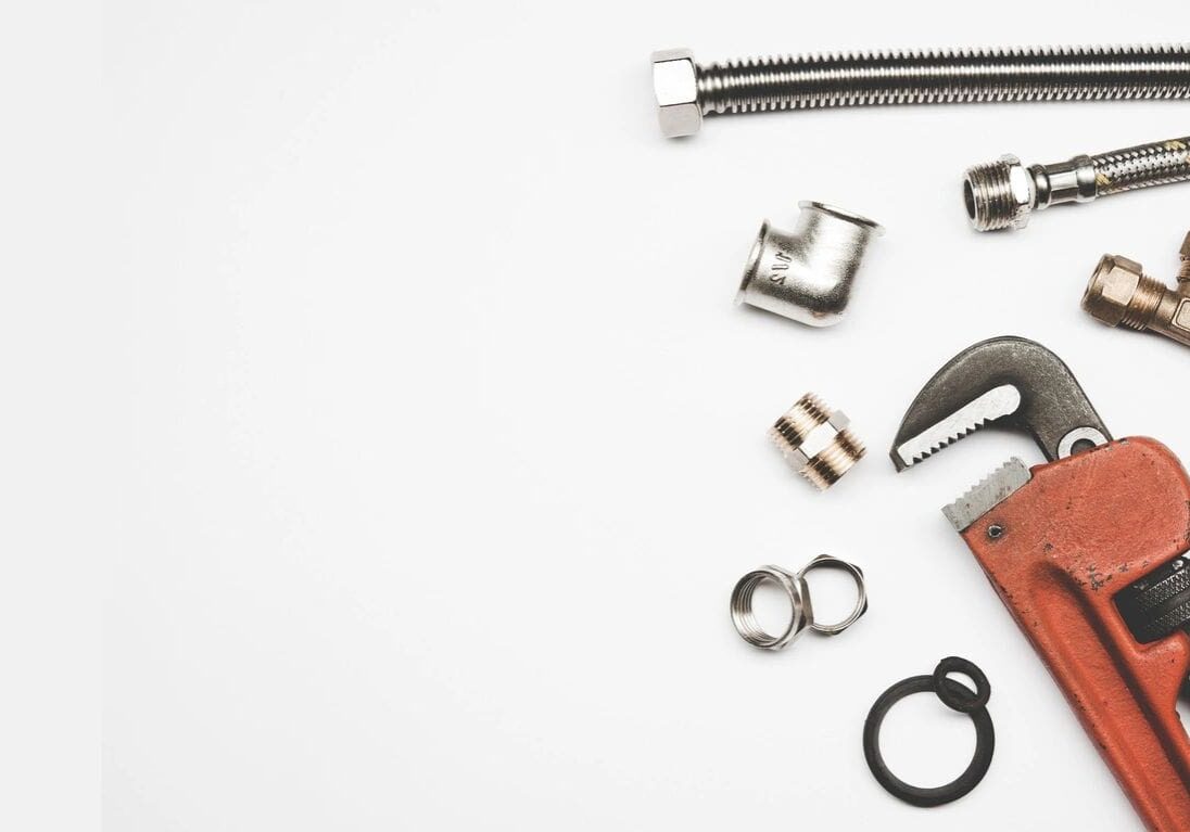 A white table topped with lots of metal items.